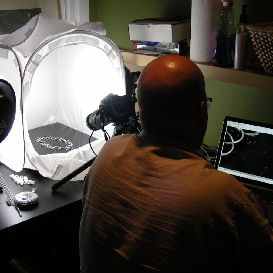 Bryan with computer and lightbox for photographing the jewelry