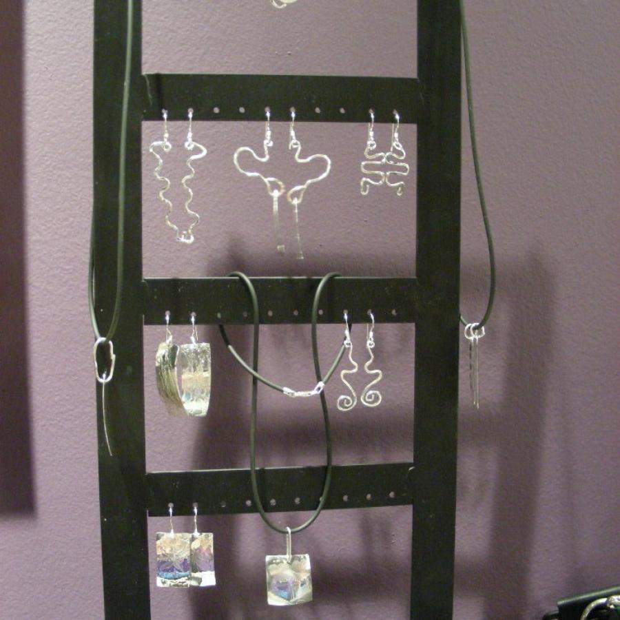 Silver earrings on a rack