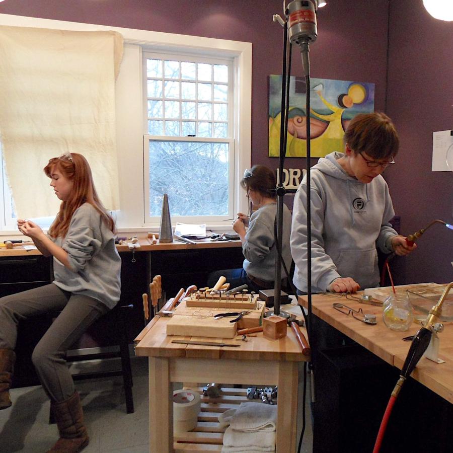 Beth and daughters working on their projects at soldering station and bench
