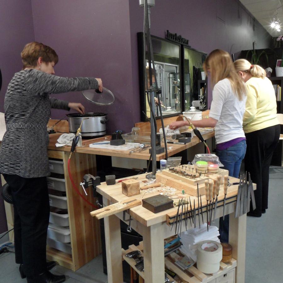 Students at solder stations working on charcoal casting