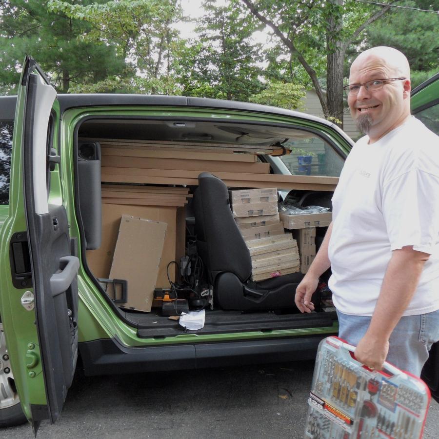 Bryan standing next to car packed with materials
