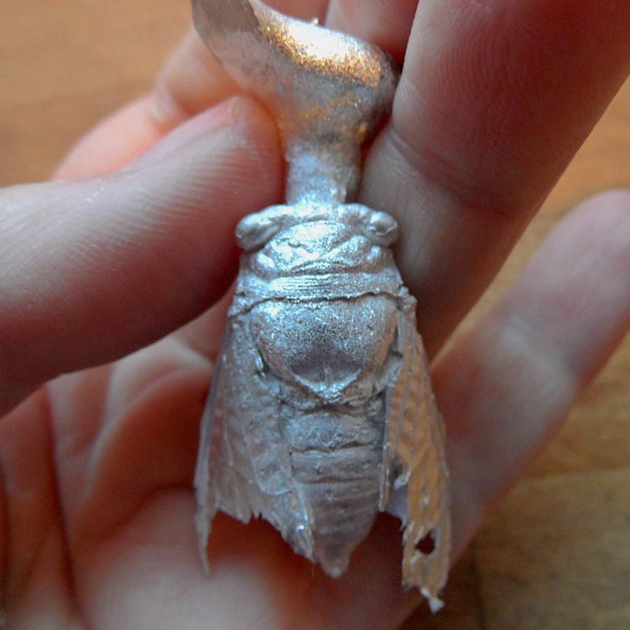 A silver cast of a Cicada