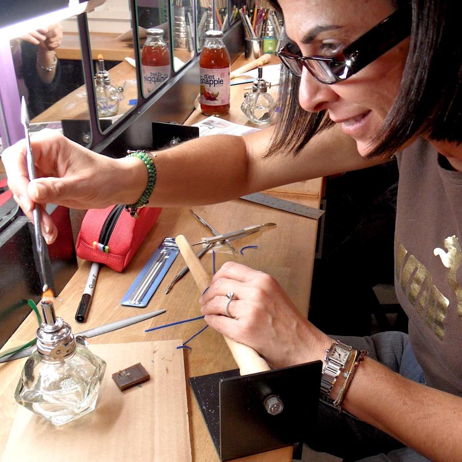 Karina using an alcohol lamp to sculpt her ring