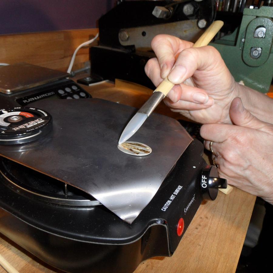 Joan Danoff working on earring on the hot plate