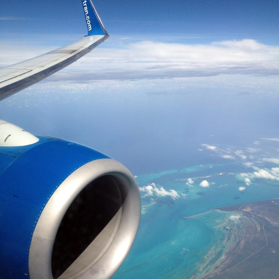 Airplane wing and engine while flying over the Bahamas