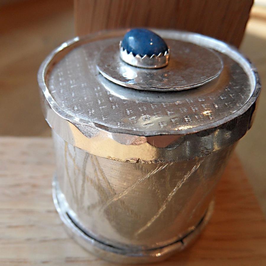 Textured silver box with blue stone set on top 
