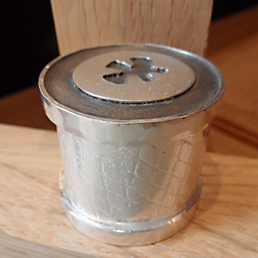 Textured silver box with puzzle piece cutout on top 