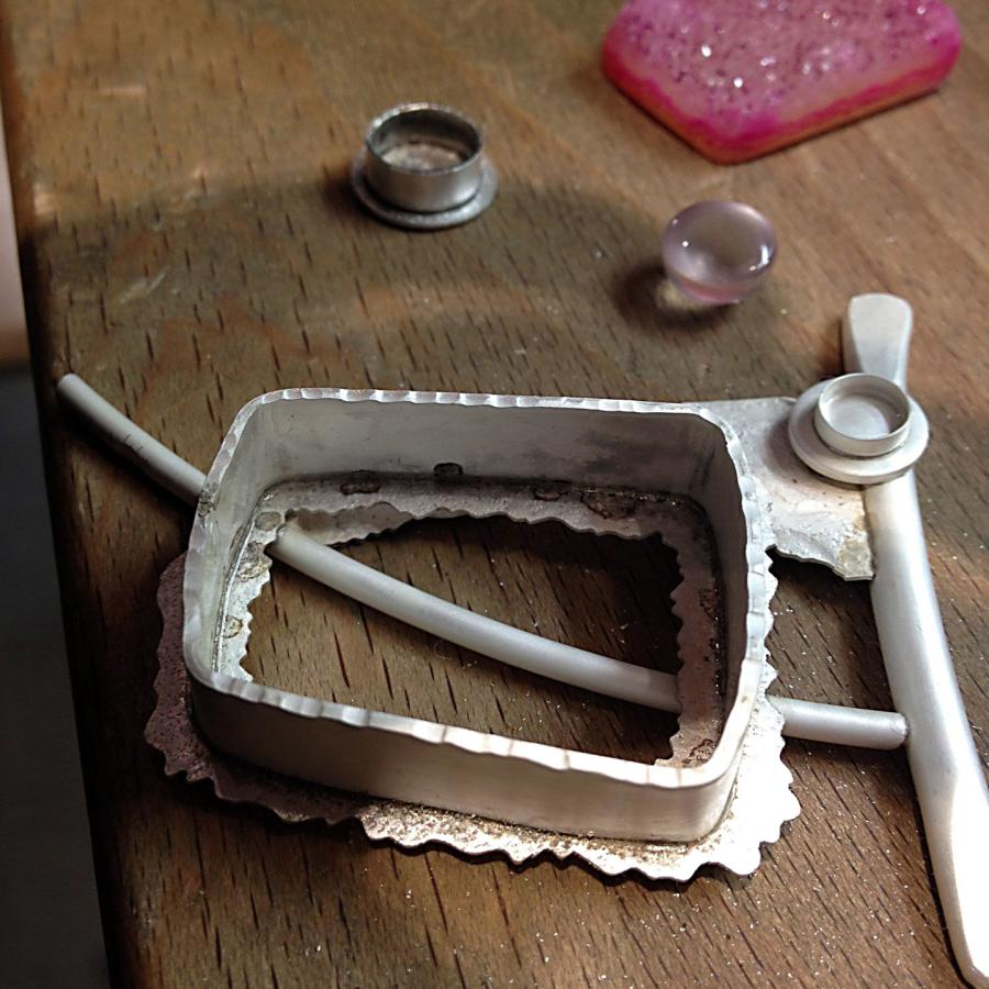 pendant in process with stones beside