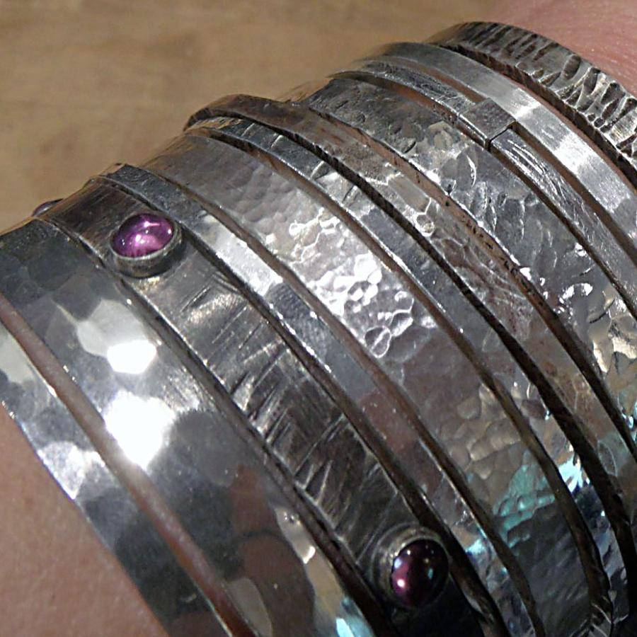 Heavy silver bangles on wrist