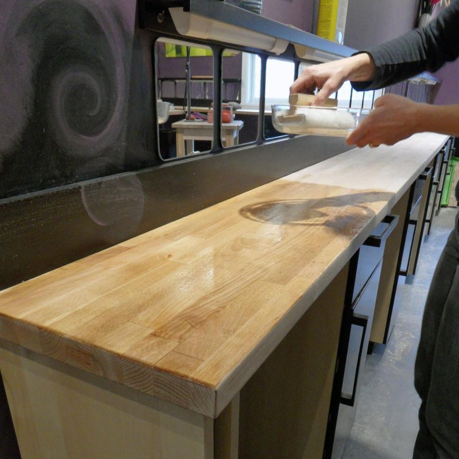 Helena oiling the newly-sanded benches