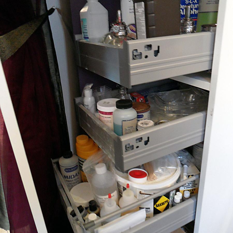 chemical cabinet open filled with different bottles in drawers