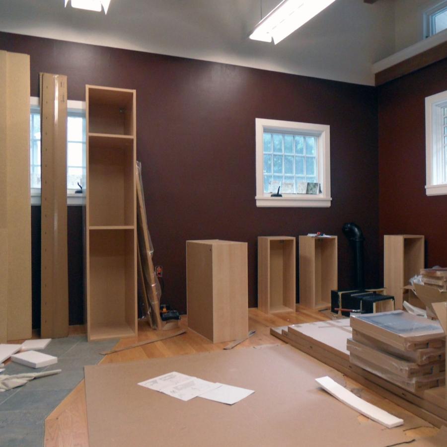 brown painted studio 2 under construction, with scattered wood planks and cabinets