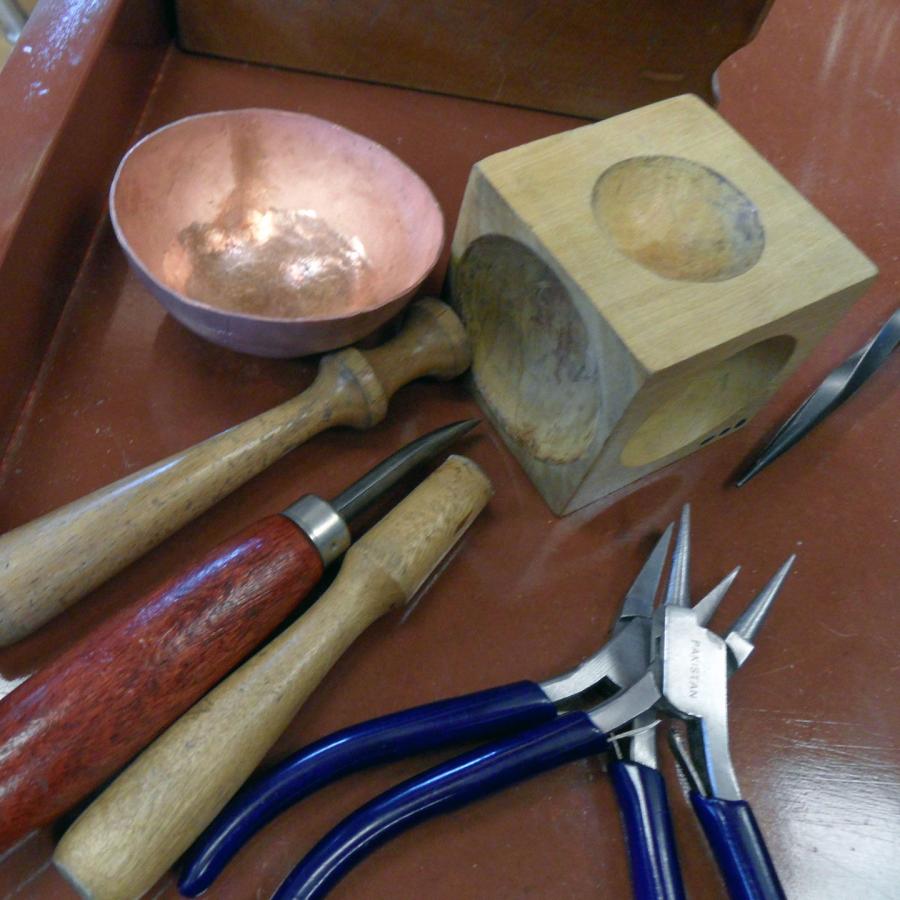copper bowl and tools used for raising including dapping tools and pliers