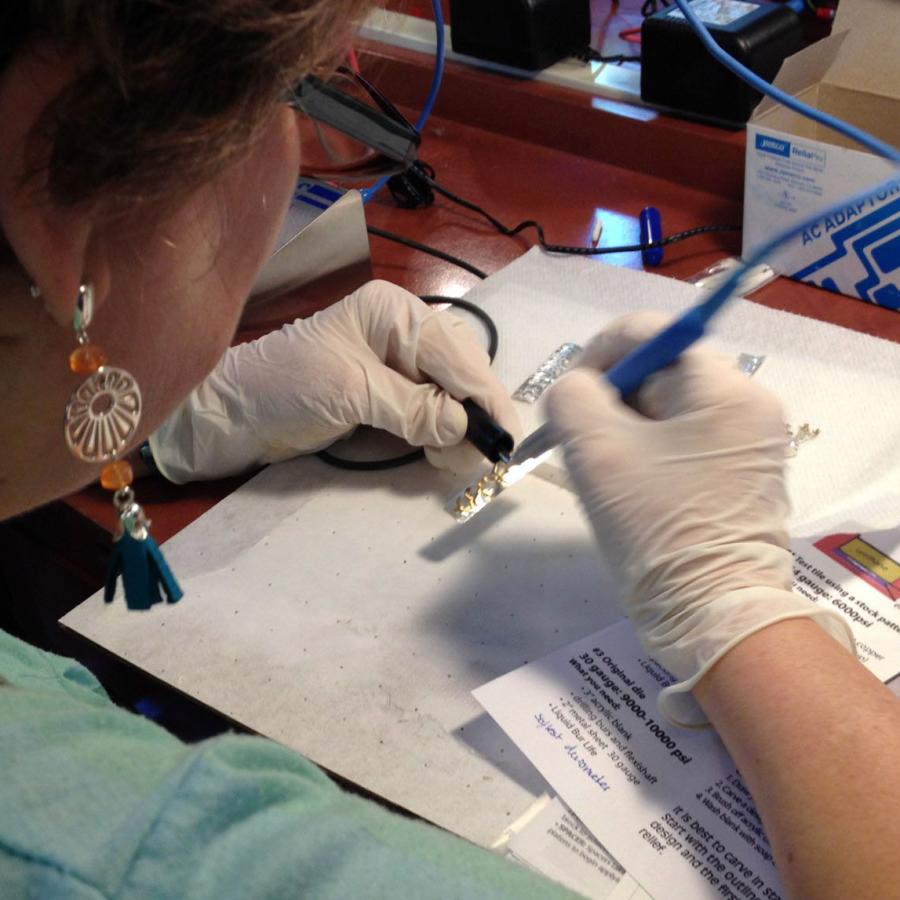 Shelly using the plating pen on rectangular silver pieces 