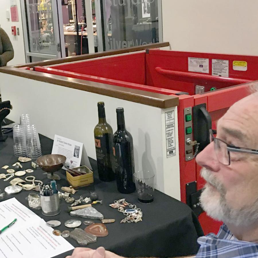 Robert sitting at his table displaying his work and techniques