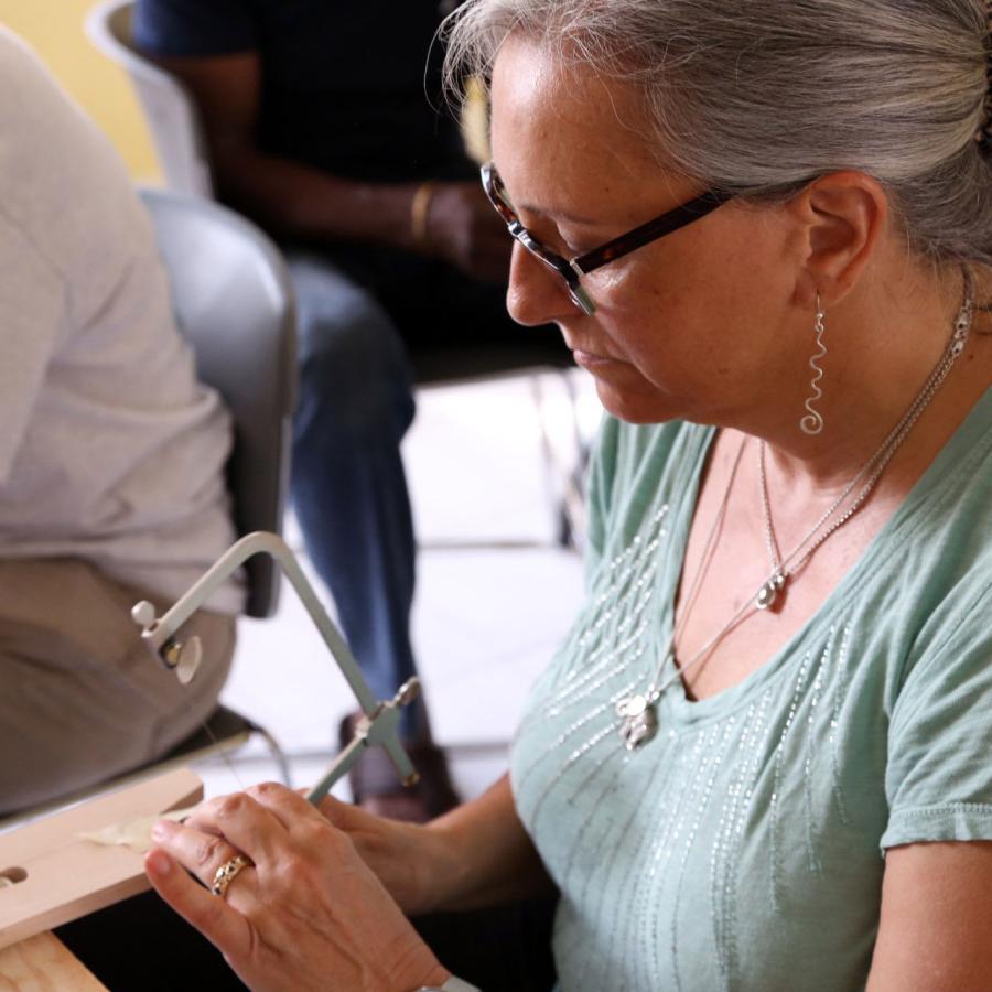 student sawing at bench pin