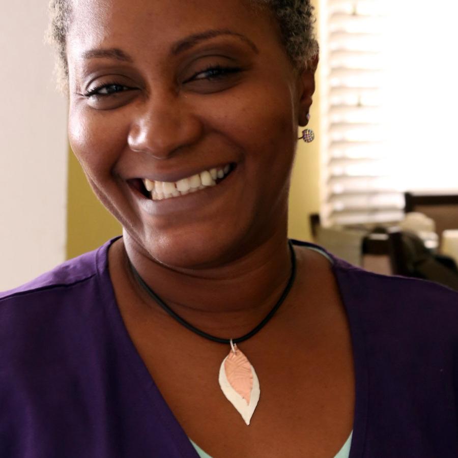 Phelice Jones smiling wearing the leaf pendant she made