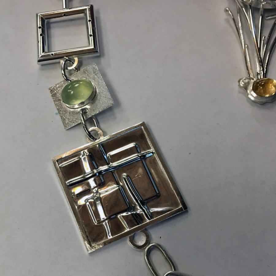 square pieces of a chain with peridot