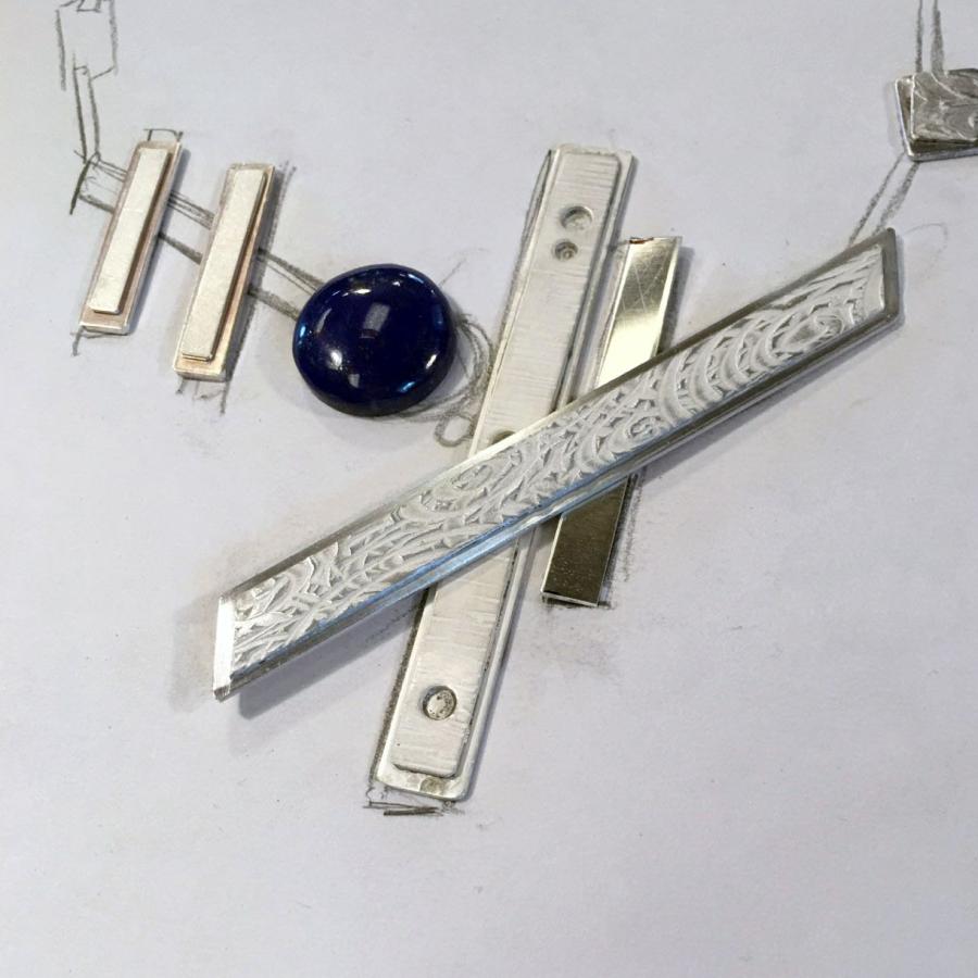 Pendant laid out on paper with blue stone