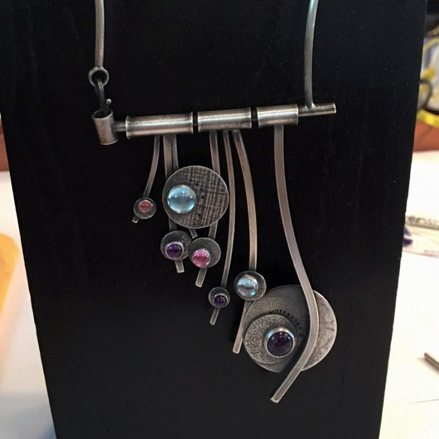 finished mounted piece - hanging strands of silver wire and blue and pink stones set on discs