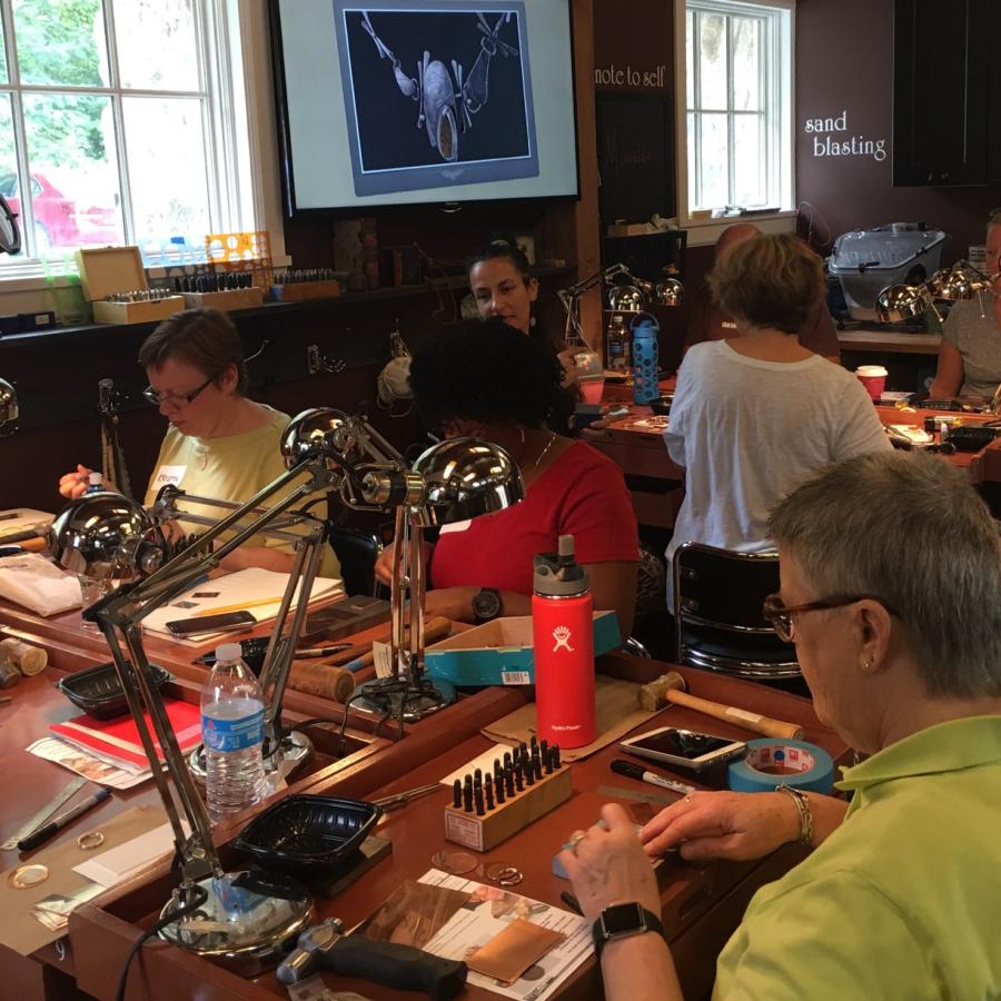 students at the benches practicing stamping