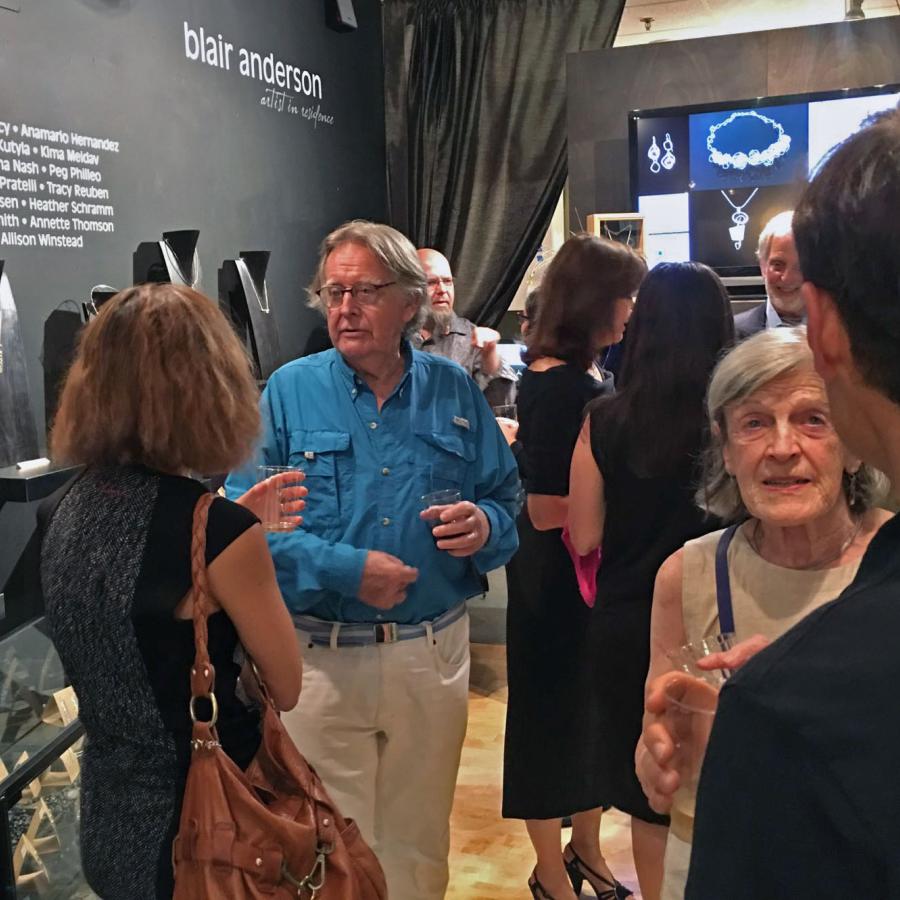 attendees of the student show mingling in the gallery