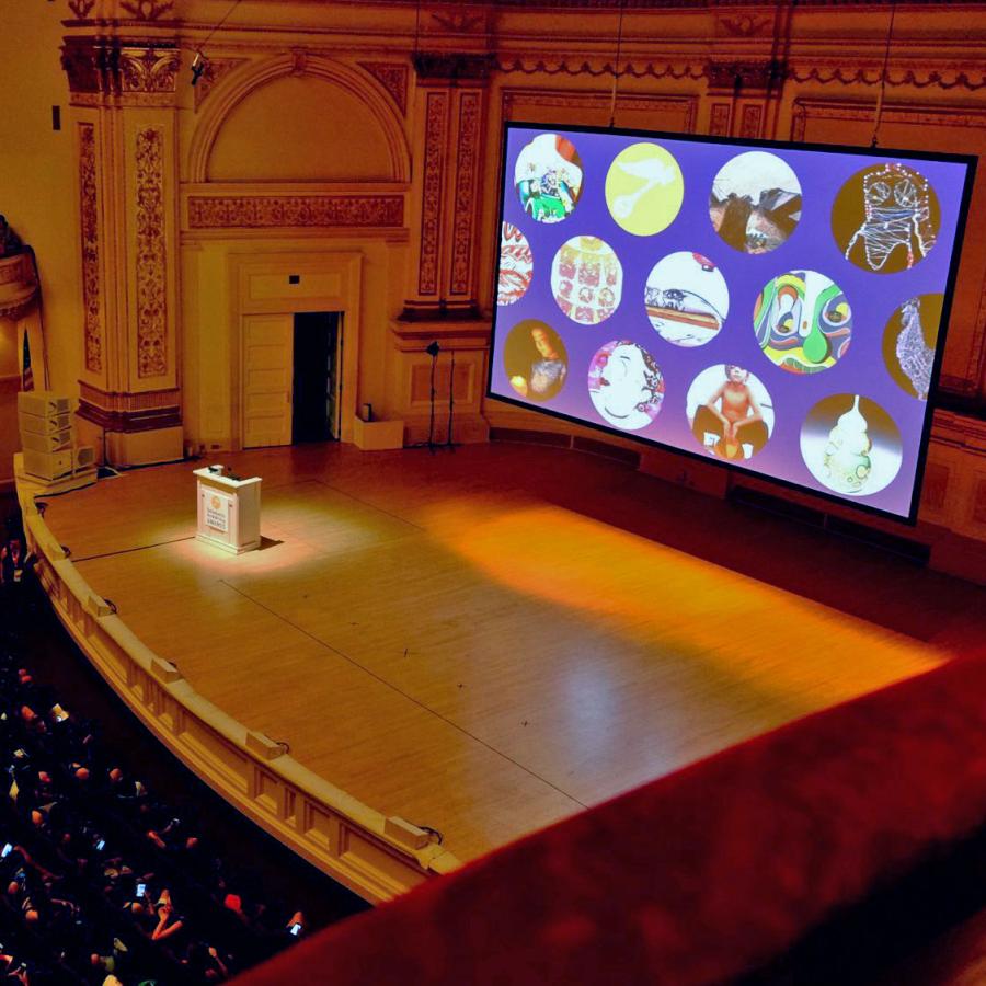 inside carnegie hall with screen presentation on stage