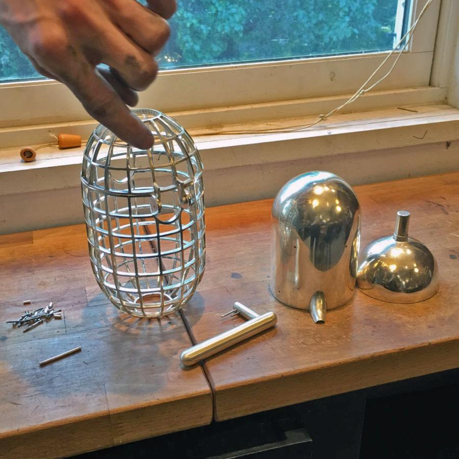 the pieces of the teapot: cage, lid, handle