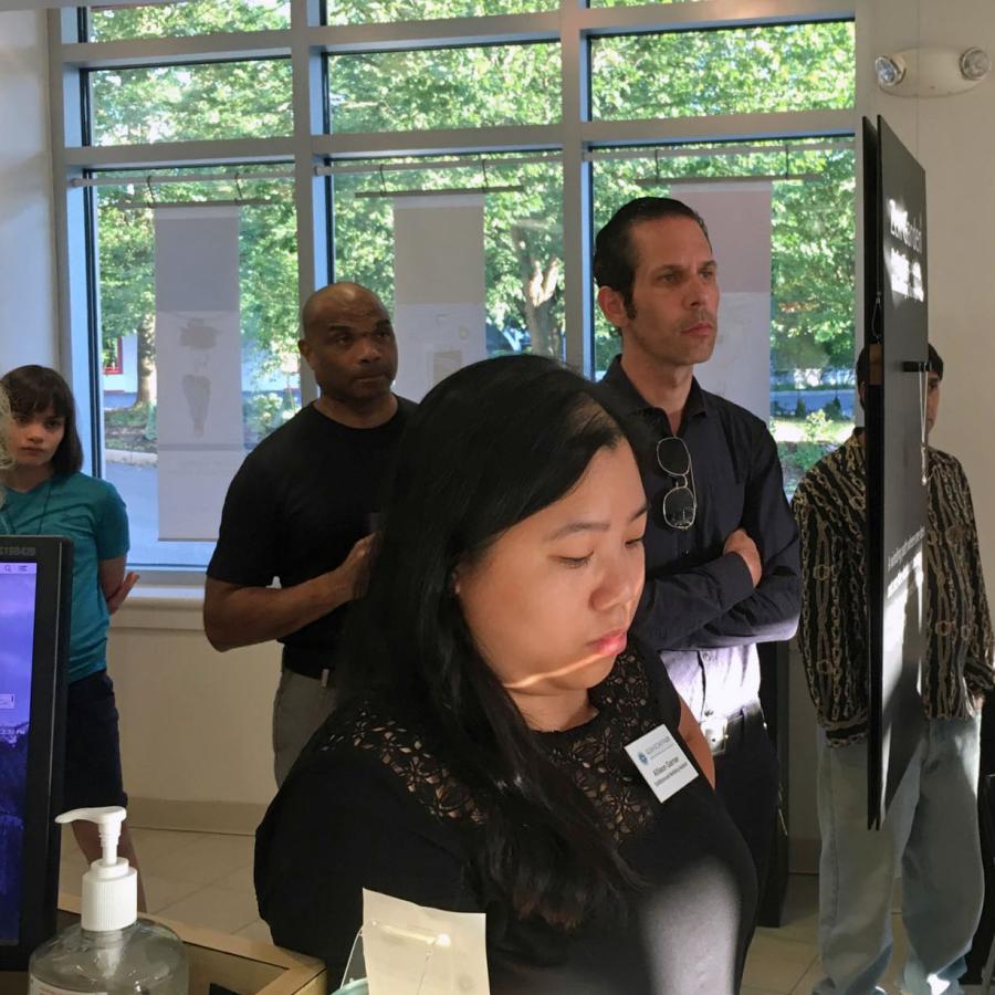 Attendees standing watching the artist talk