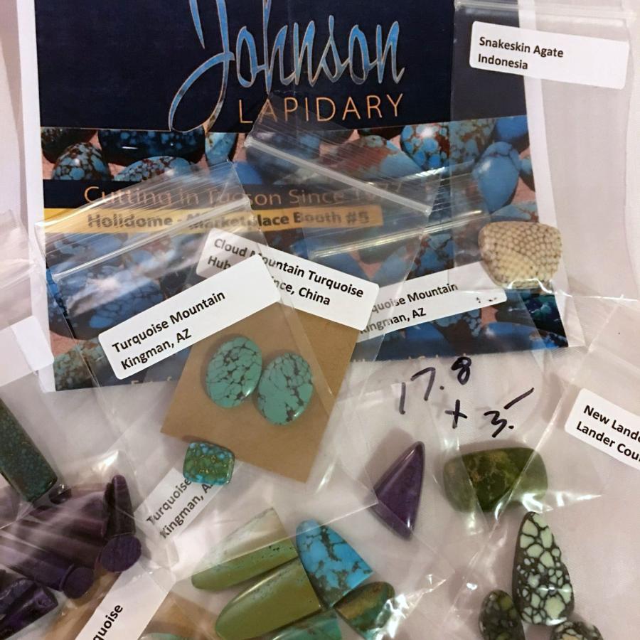 variety of turquoise and agate in packets next to company card