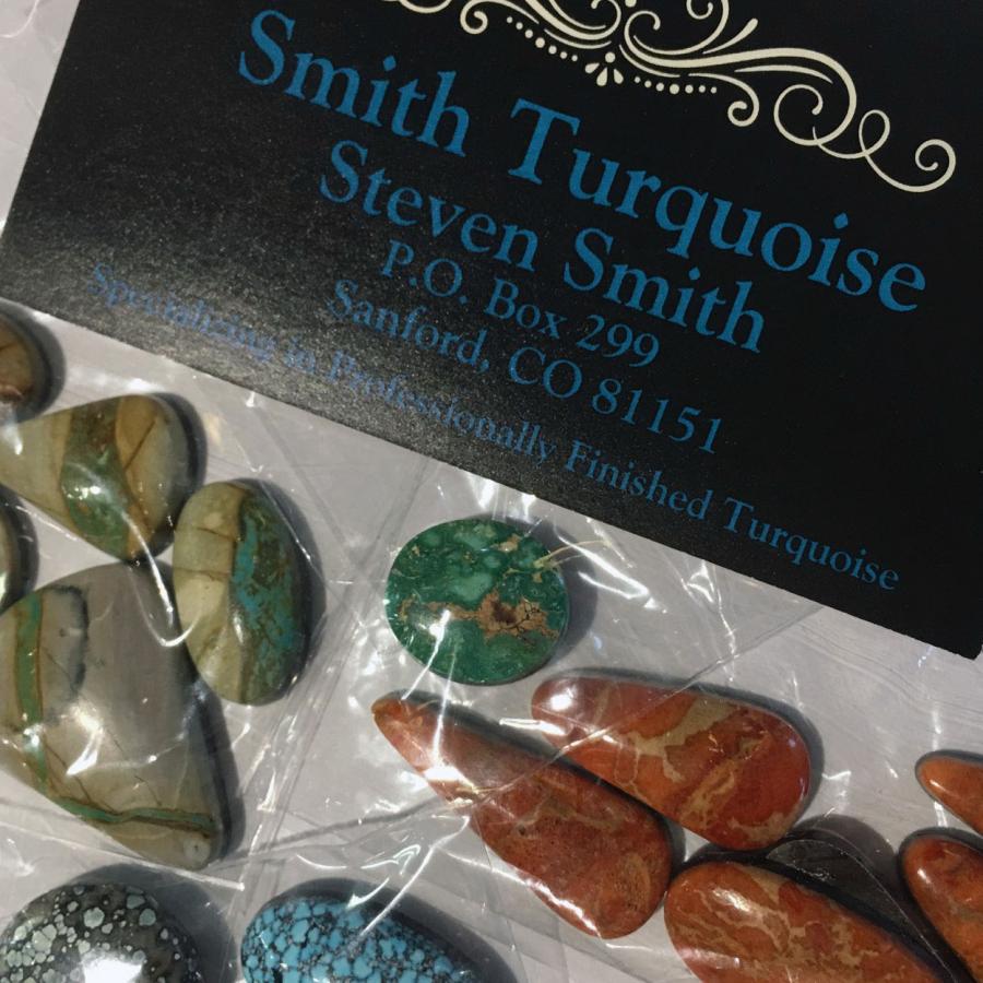 green-brown and red-orange stones next to company card