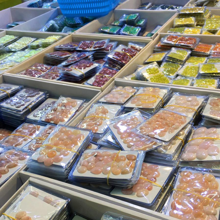 numerous stones of different colors laid out in bags and trays