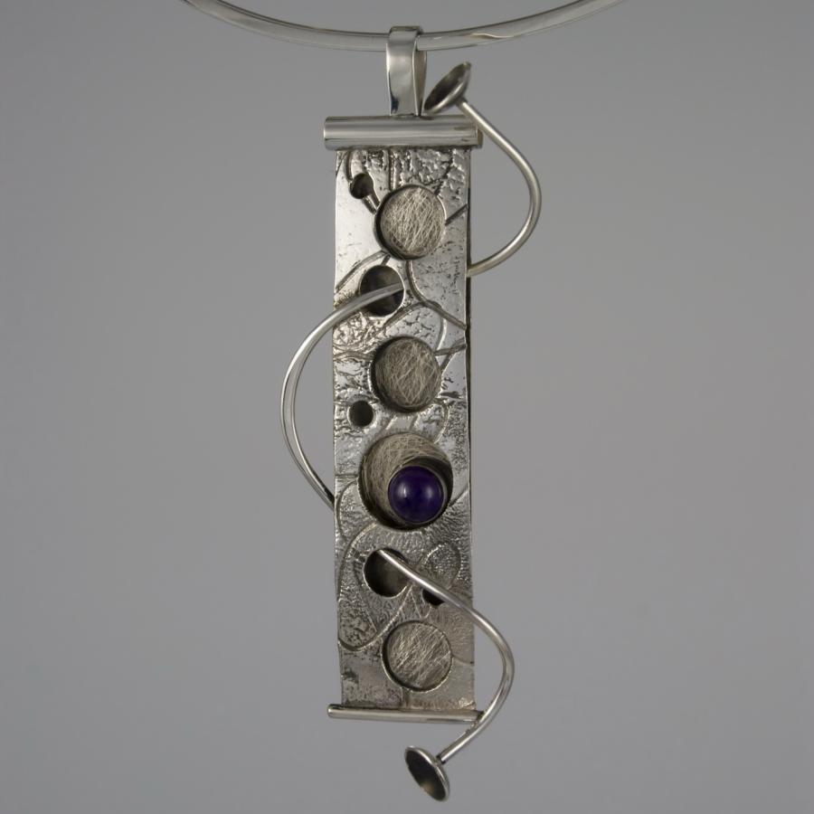 Silver necklace with amethyst, close-up photograph.