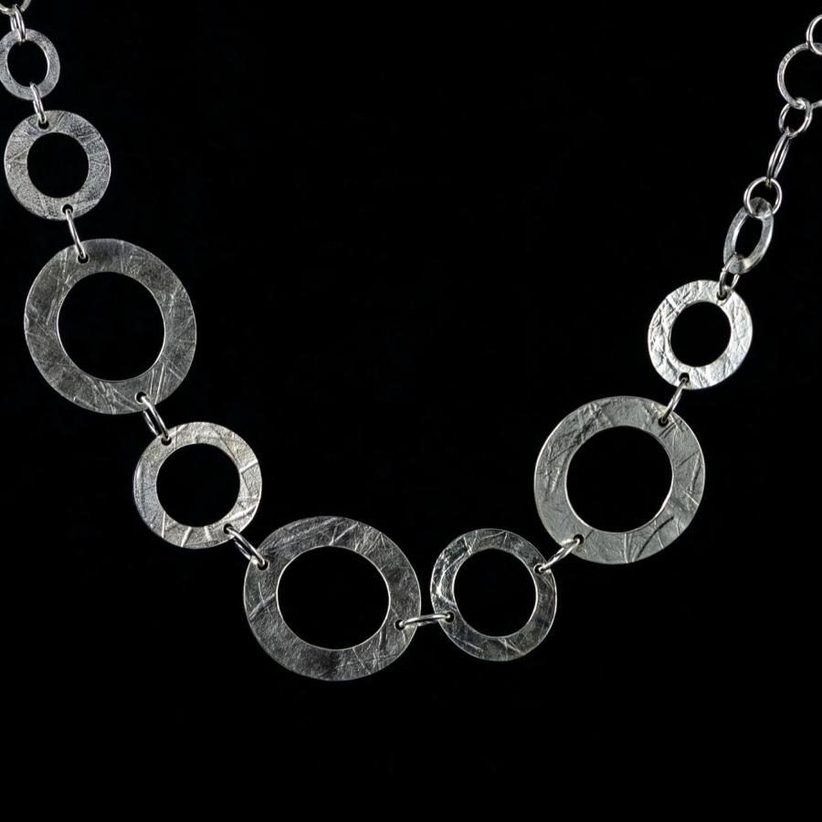 Silver necklace with textured circular links.