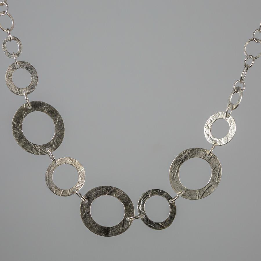 Silver necklace with textured circular links.