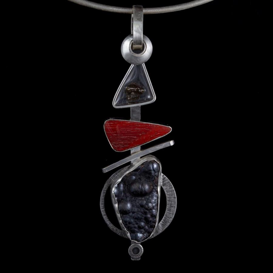 Silver pendant necklace with red and black stones.