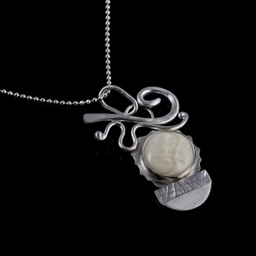 Silver pendant with carved ivory moon face