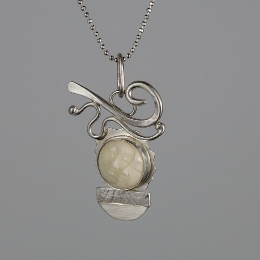 Silver pendant with carved ivory moon face