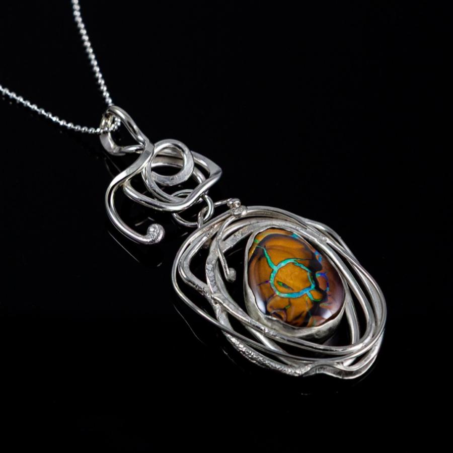 Silver necklace with intricate pendant and oval bolder opal.