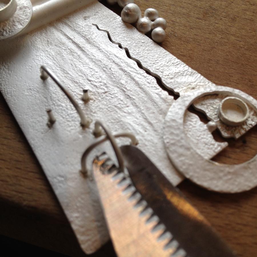 Close-up of silver jewelry making tools and materials.