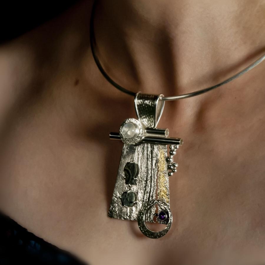 Woman wearing artistic silver pendant necklace.
