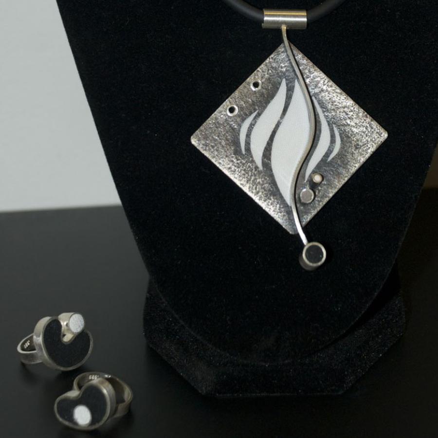 Photograph of jewelry set, pendant necklace and two rings.