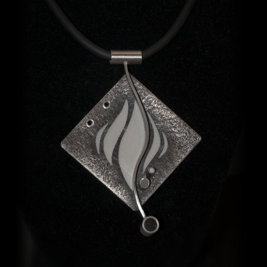 Silver pendant necklace, close-up photograph.