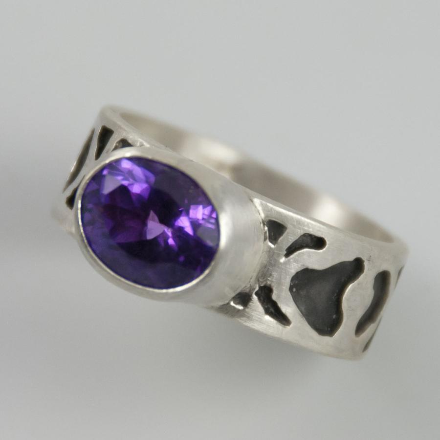 Silver ring with oval purple stone, photograph.