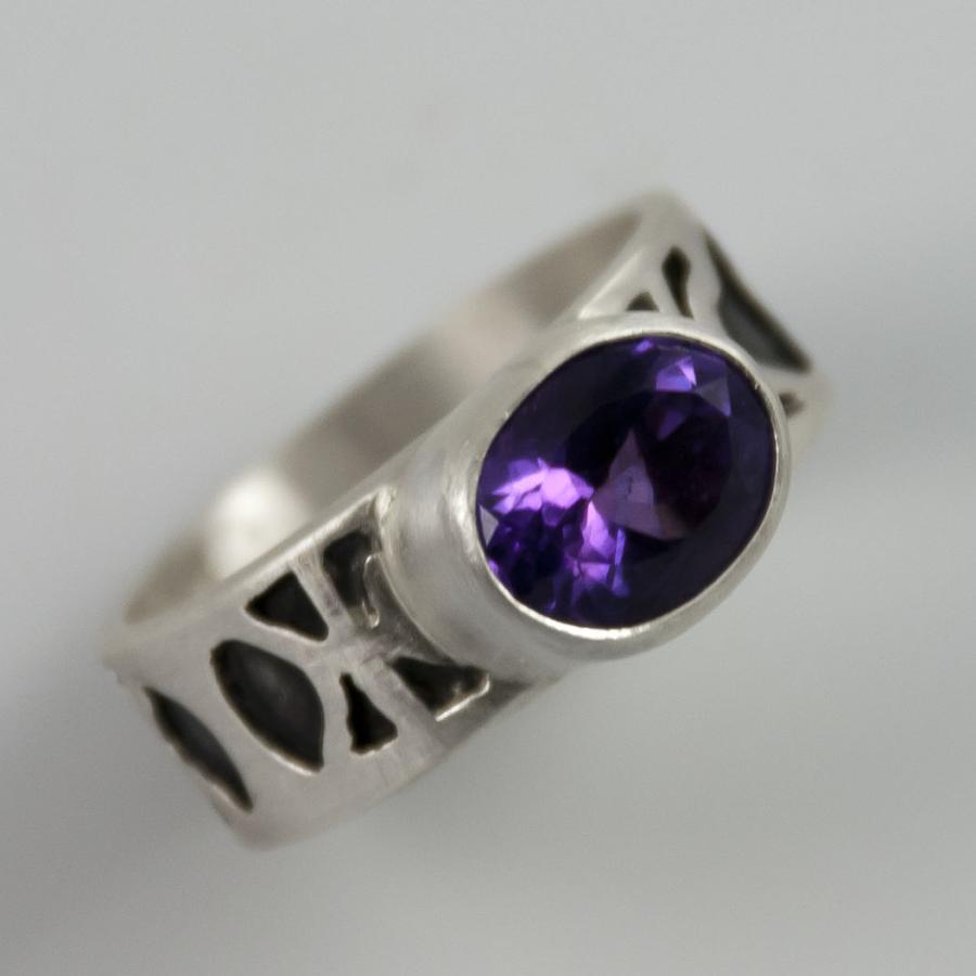 Silver ring with oval purple stone, photograph.