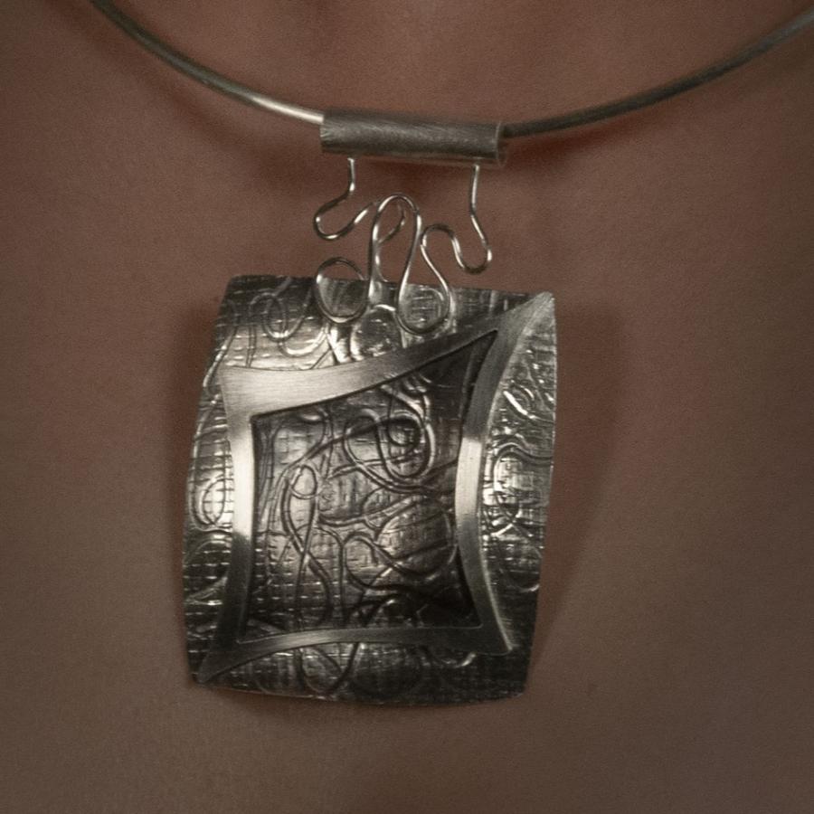 Woman's neck with a silver necklace.