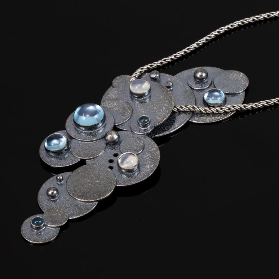 Silver necklace with blue gemstones, photograph.