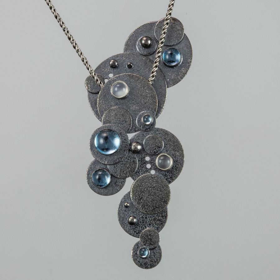 Silver necklace with blue and clear gems.