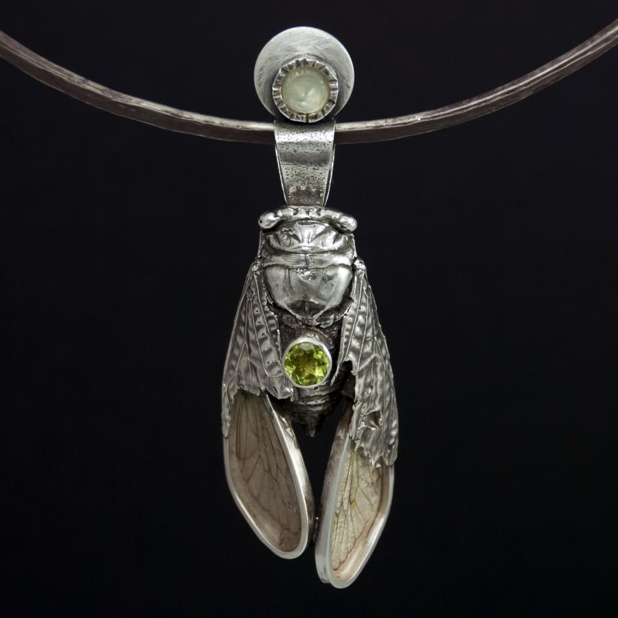 Silver cicada pendant necklace, studio photograph.