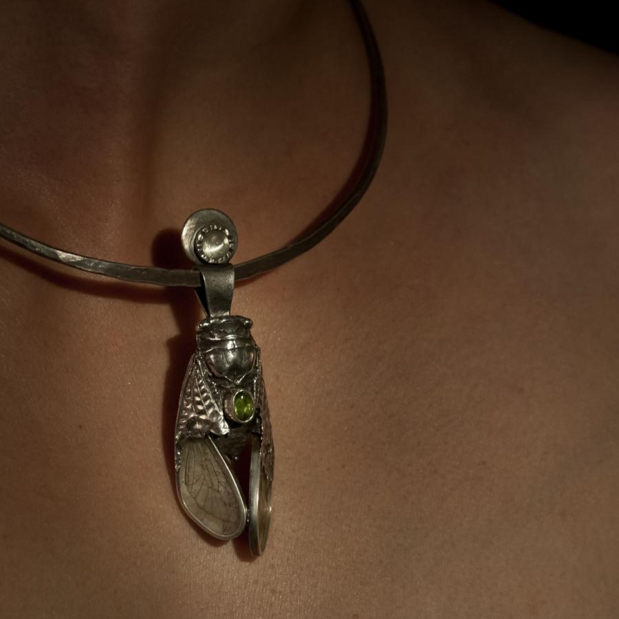 Person wearing silver Cicada pendant necklace.